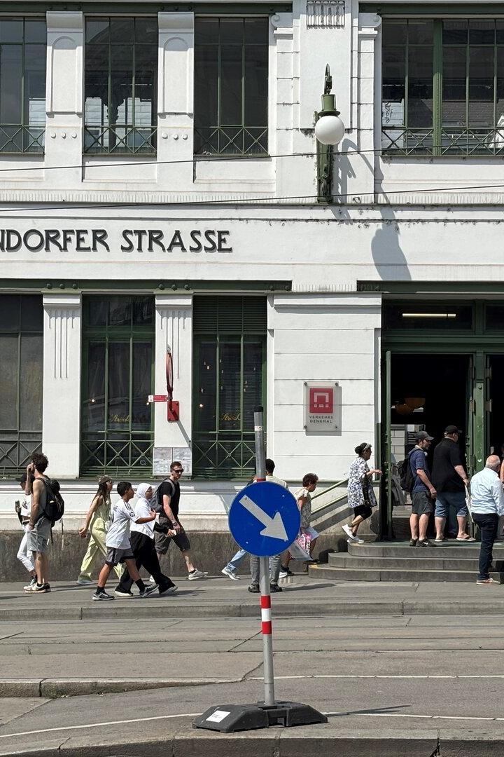 Menschen gehen vor dem historischen Gebäude der U-Bahn-Station Gumpendorfer Straße in Wien ein und aus, während Polizisten vor dem Eingang stehen.