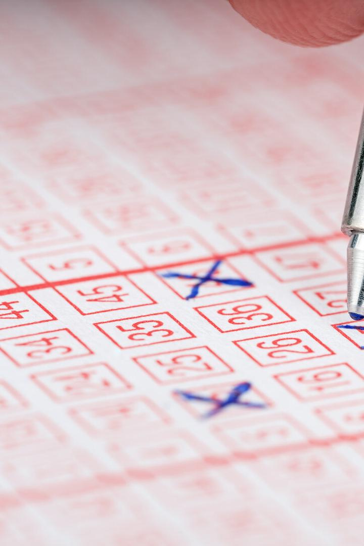 Close-up of a pen marking numbers on a lottery ticket.
