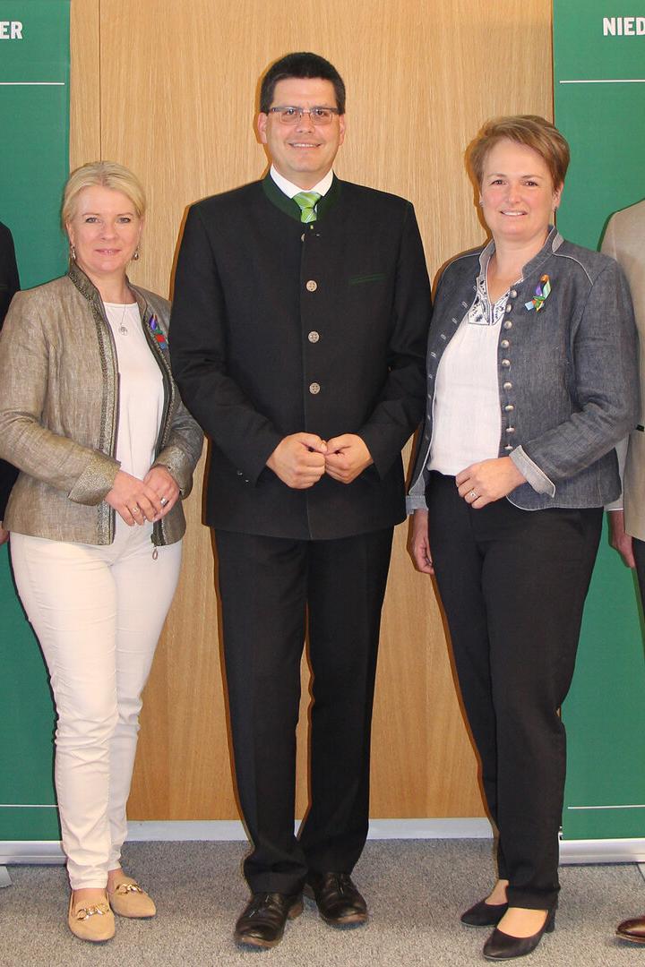 Fünf Personen in Tracht stehen vor Bannern des Niederösterreichischen Bauernbunds.