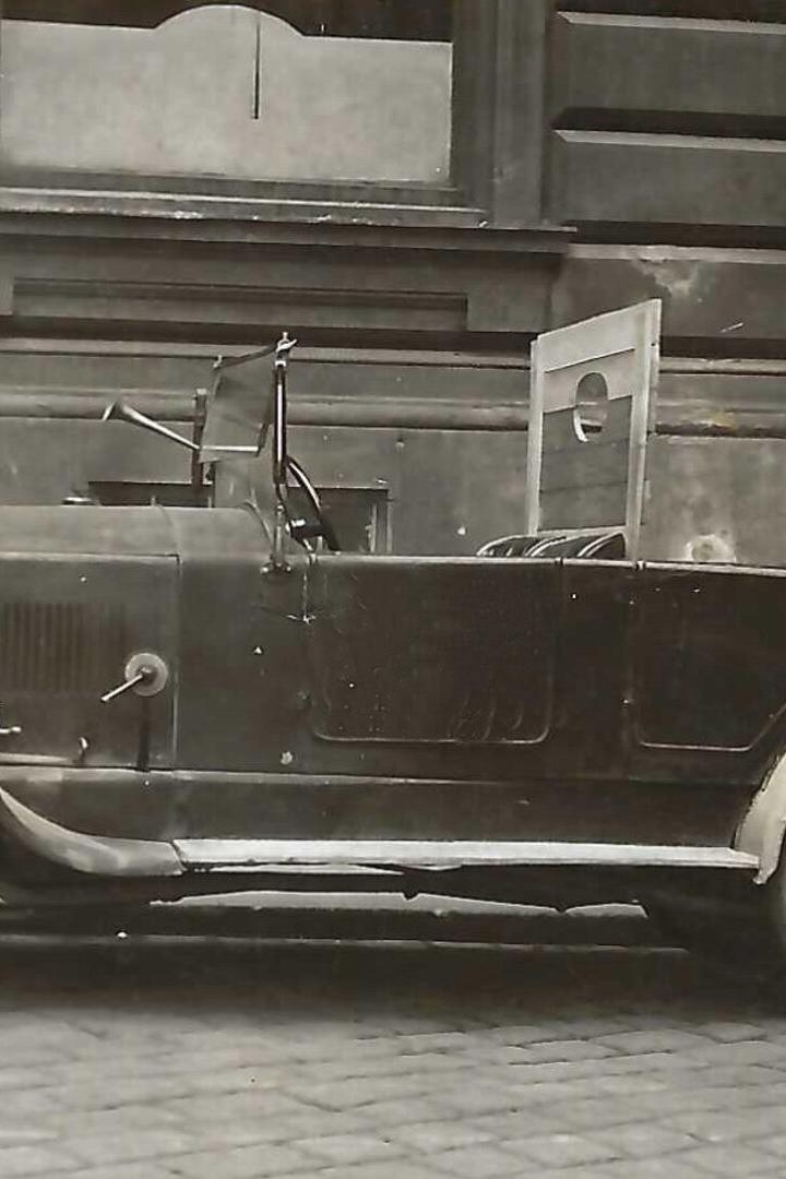 Altes schwarzes Cabrio vor einem Gebäude geparkt.