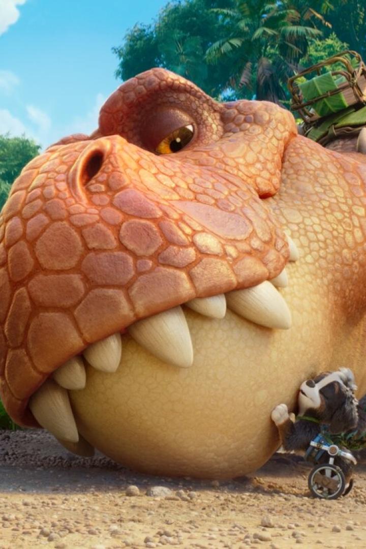 Marshall von der Paw Patrol steht in einem Dschungel vor einem großen T-Rex, an dessen Kopf ein kleiner Hund mit Rollstuhl lehnt.