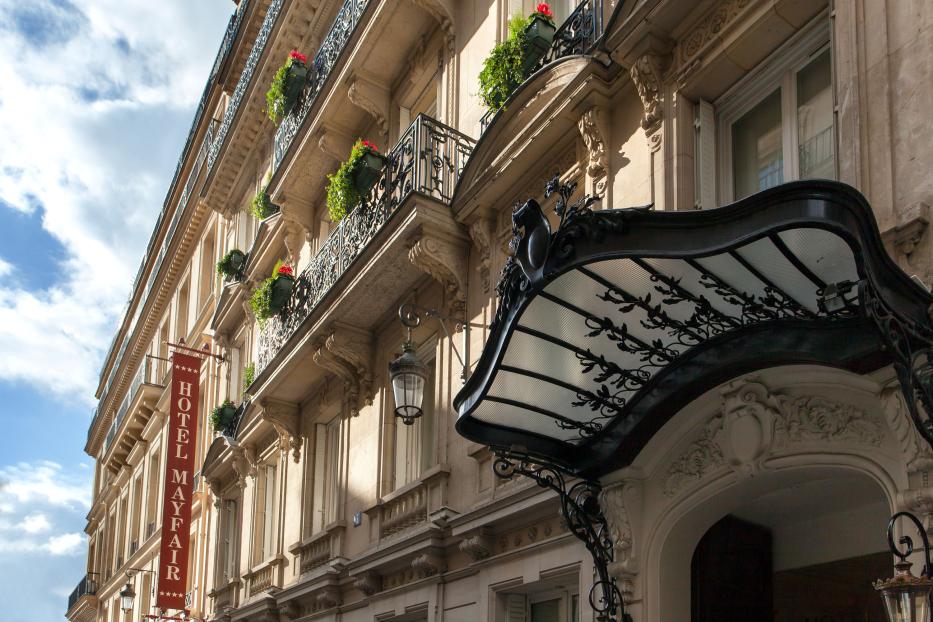 Das Hotel Mayfair in Paris mit kunstvoller Fassade und schmiedeeisernem Vordach.
