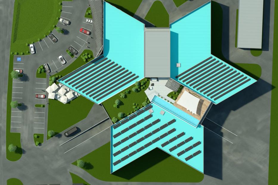 Draufsicht eines modernen, sternförmigen Gebäudes mit Solarpaneelen auf dem Dach.