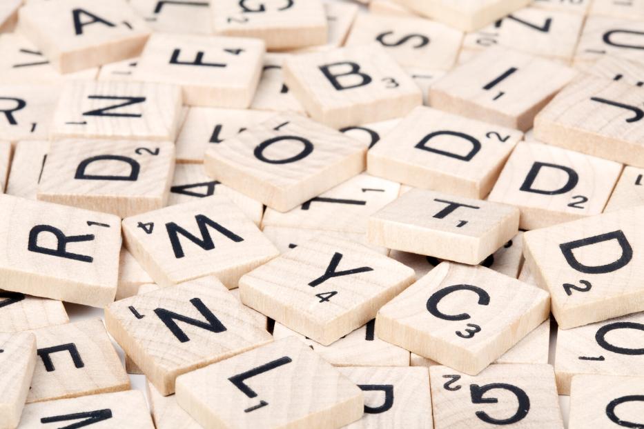Nahaufnahme von hölzernen Scrabble-Buchstabensteinen.