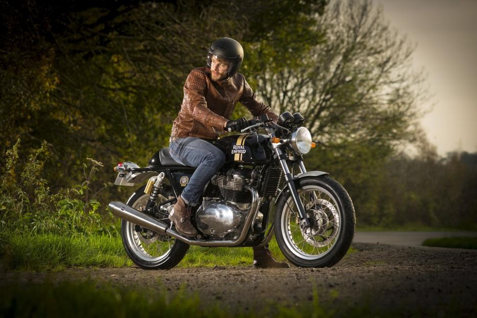 Ein Mann mit Lederjacke und Helm sitzt auf einem Royal Enfield Motorrad.