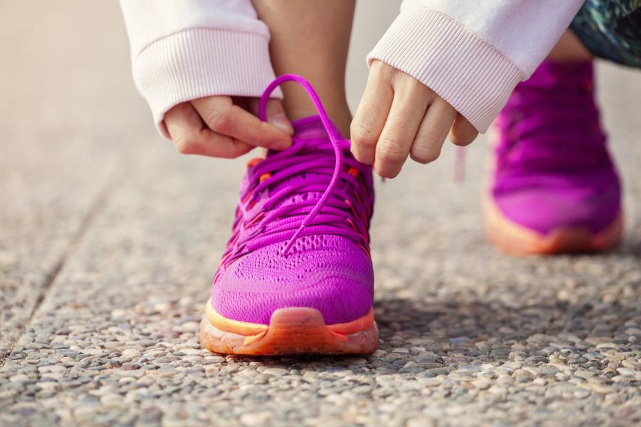 Läuferin schnürt Laufschuhe.