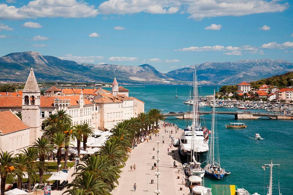 Die Hafenpromenade von Trogir mit Blick auf das Meer und die Berge.