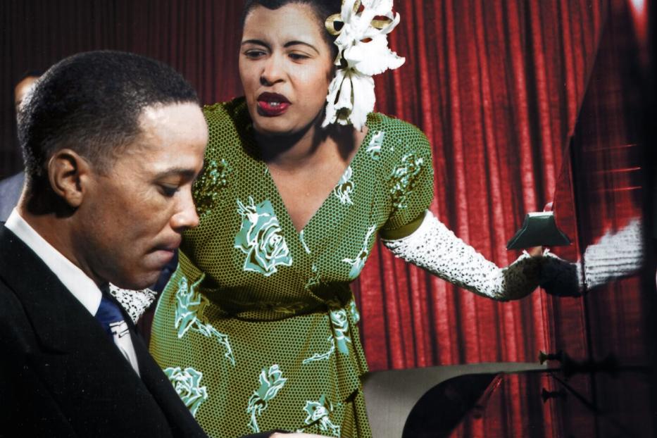 Billie Holiday singt, während ein Pianist sie begleitet.