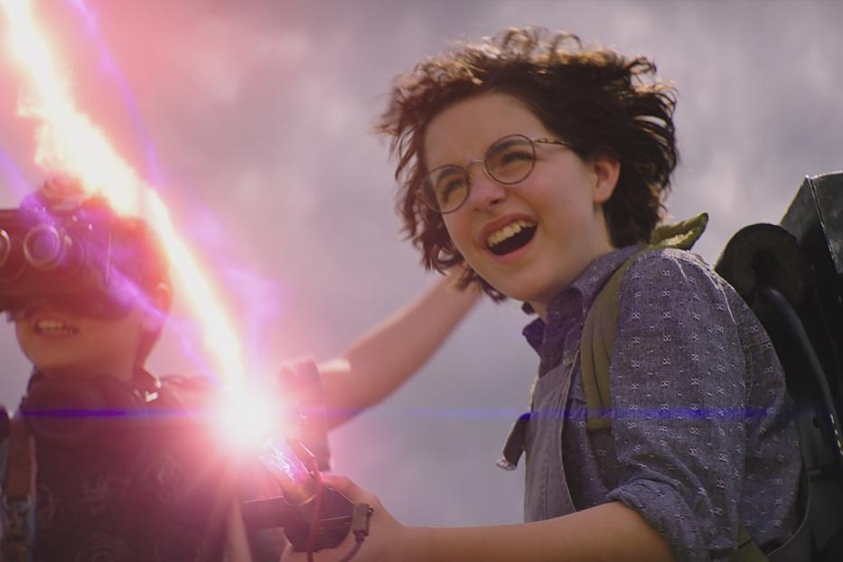 Zwei Kinder, mit Ghostbusters-Ausrüstung ausgestattet, strahlen mit ihren Protonenstrahlern.