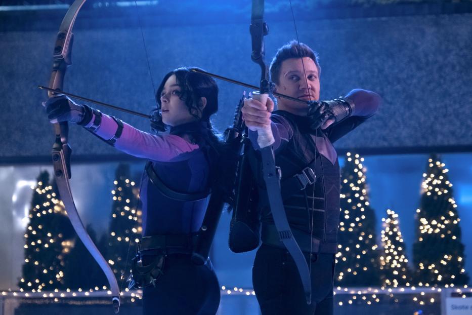 Kate Bishop und Clint Barton, beide als Hawkeye, zielen mit Pfeil und Bogen.
