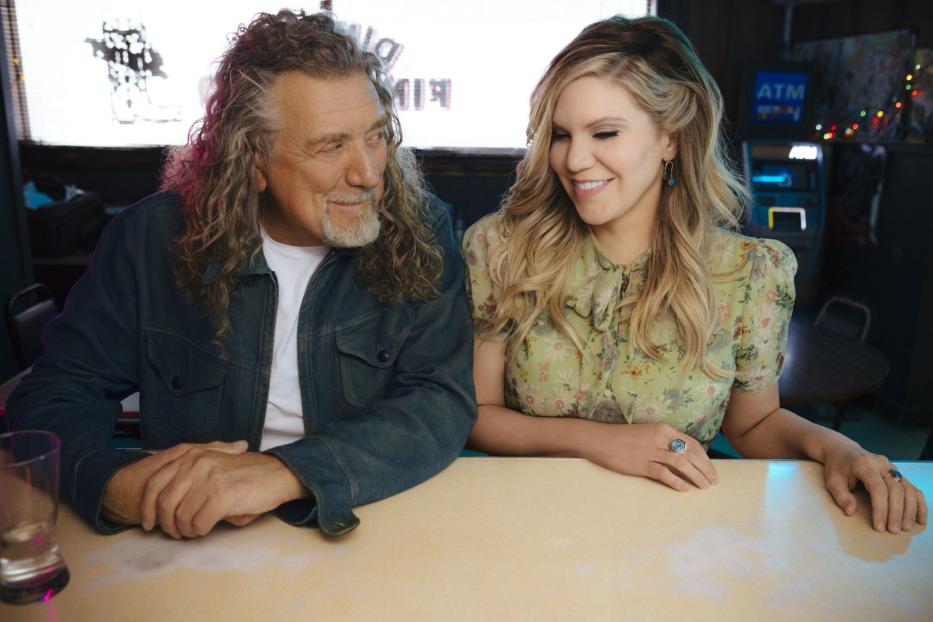 Robert Plant und Alison Krauss sitzen an einem Tisch und schauen sich an.