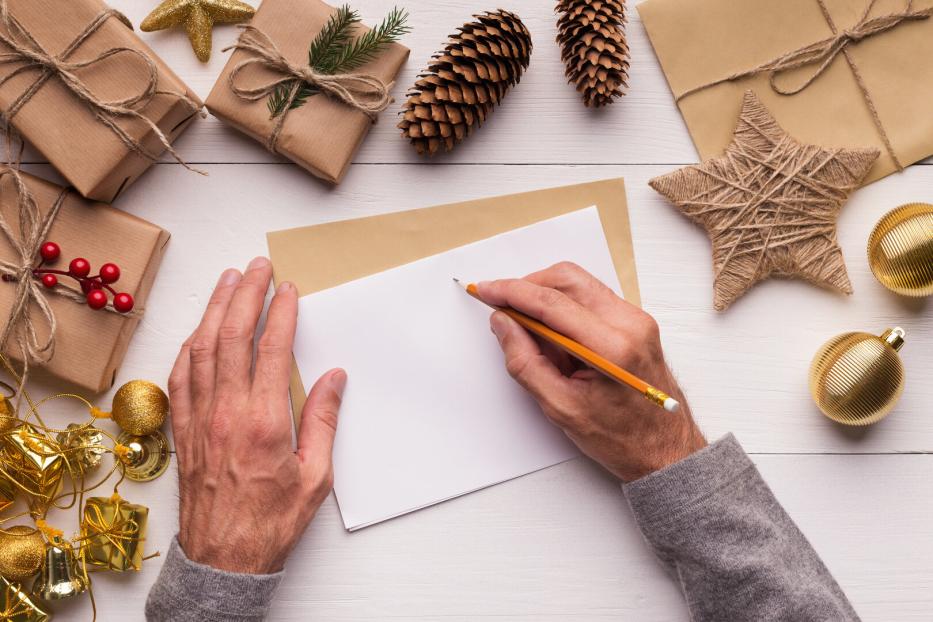 Erwachsener, der ein Brief ans Christkind schreibt.