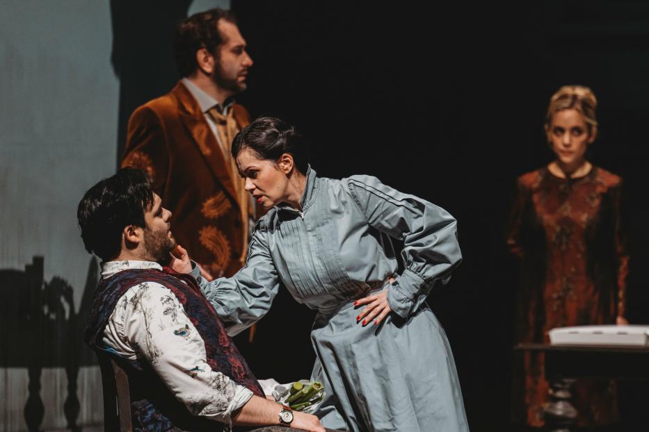 Eine Szene aus einem Theaterstück mit fünf Darstellern auf der Bühne.