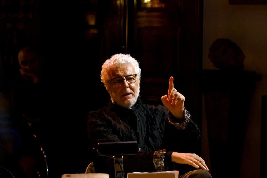 Ein Mann mit weißem Haar und Brille gestikuliert mit erhobenem Zeigefinger.