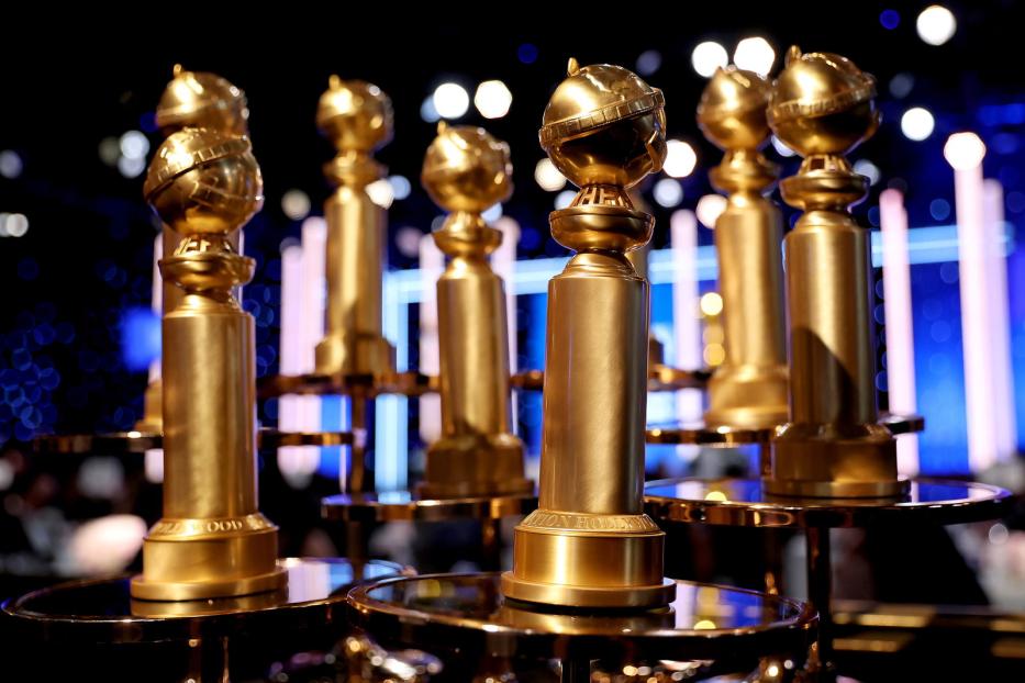 Mehrere goldene Golden Globe Awards stehen auf Tischen.