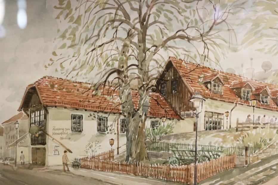 Aquarellmalerei eines Gasthofs mit rotem Ziegeldach und einem Baum davor.