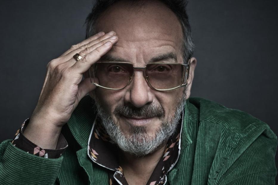 Porträt von Elvis Costello mit Brille und Cordjacke.