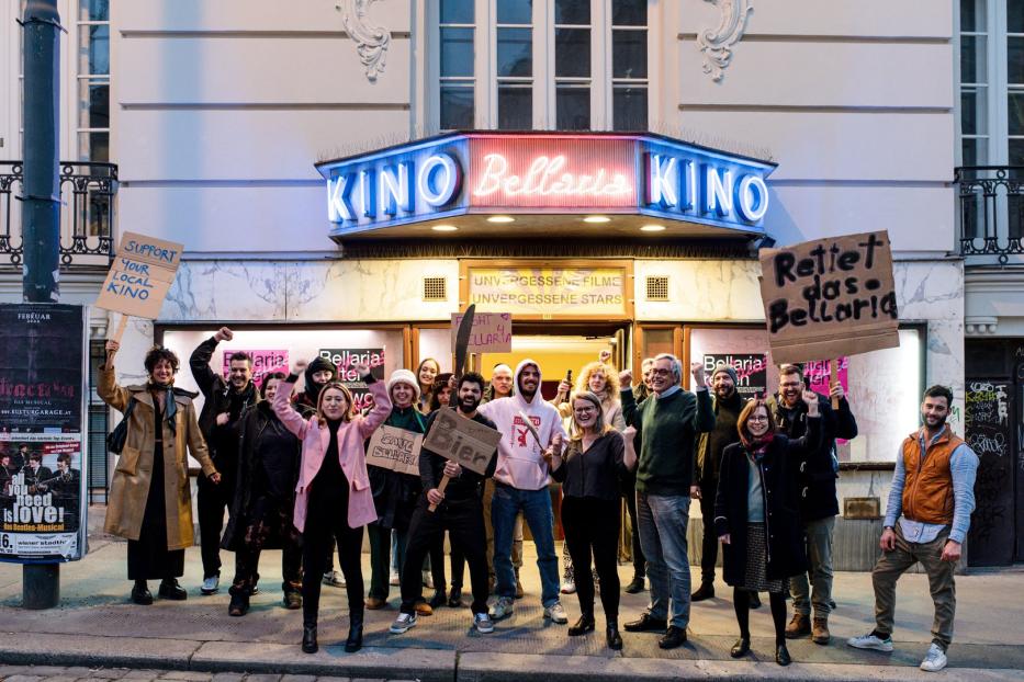 Eine Gruppe von Menschen demonstriert vor dem Kino Bellaria mit Schildern, um es zu retten.