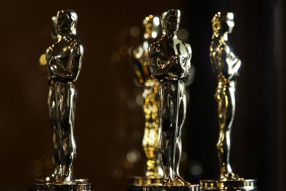 Mehrere goldene Oscar-Statuetten stehen auf einem Tisch.