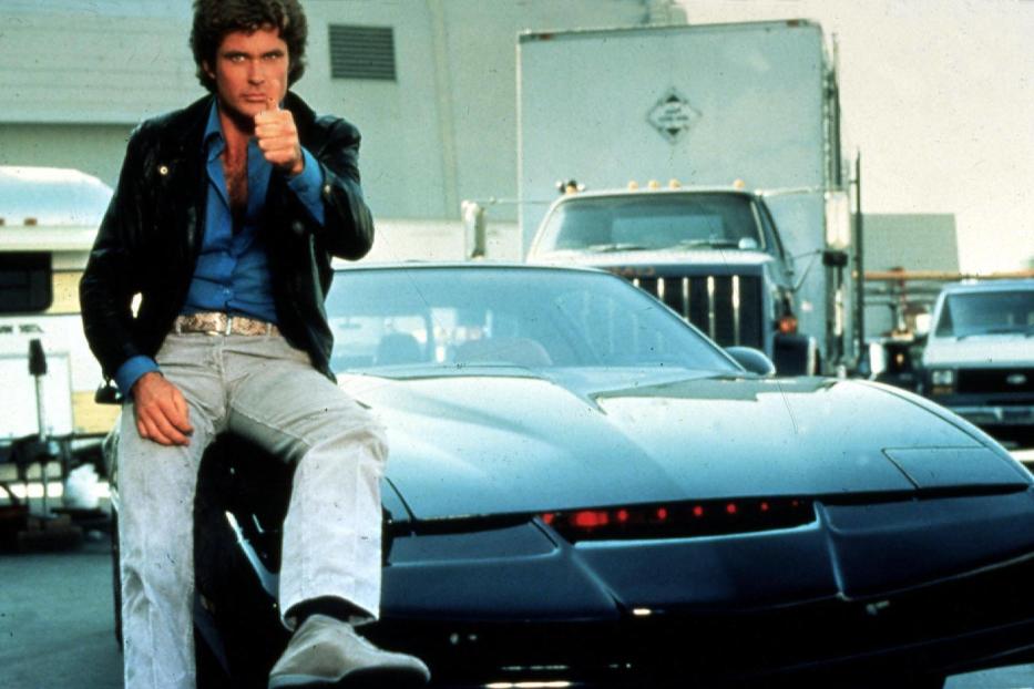 David Hasselhoff posiert auf dem Auto K.I.T.T. aus der Serie „Knight Rider“.