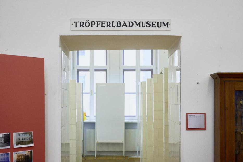Ein Blick in das Tröpferlbadmuseum durch einen gefliesten Eingang.