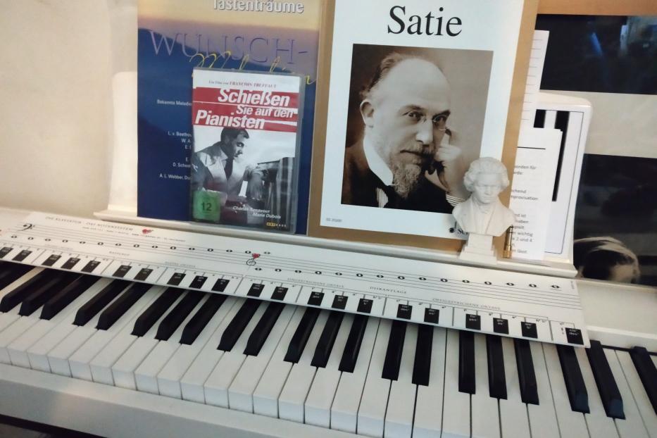 Ein Klavier mit Notenblättern, einer Film-DVD und einer kleinen Beethoven-Büste.