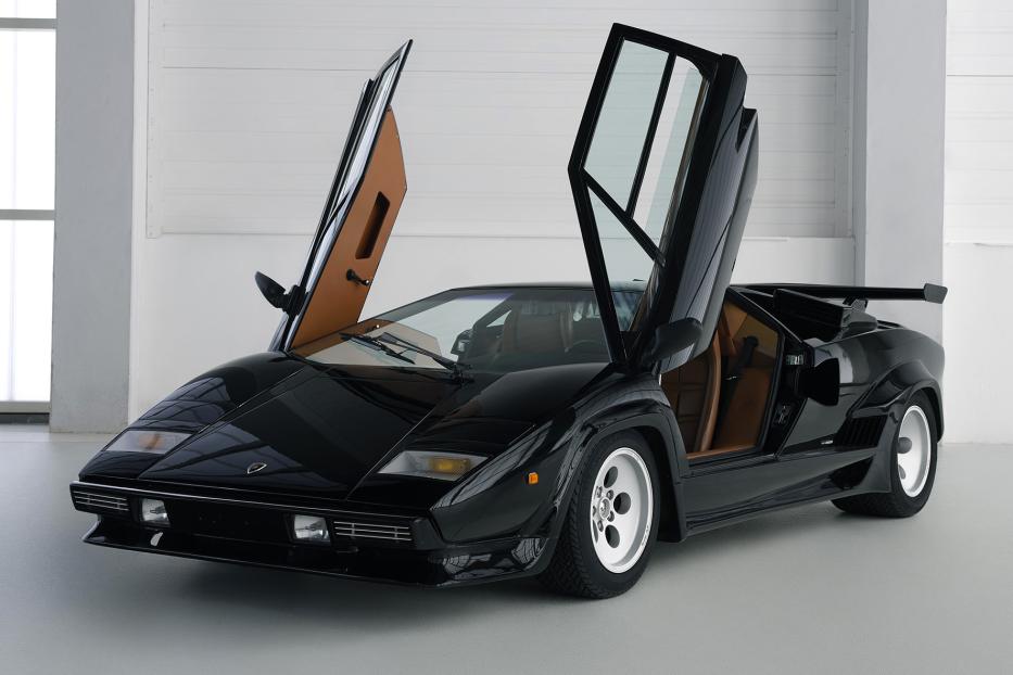 Ein schwarzer Lamborghini Countach mit geöffneten Flügeltüren steht in einem Studio.