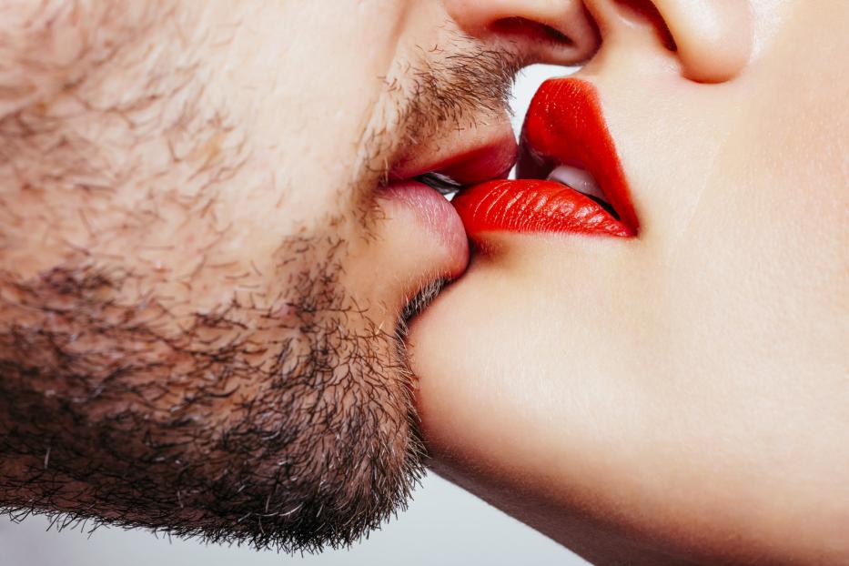 Ein Paar küsst sich; die Frau trägt roten Lippenstift.