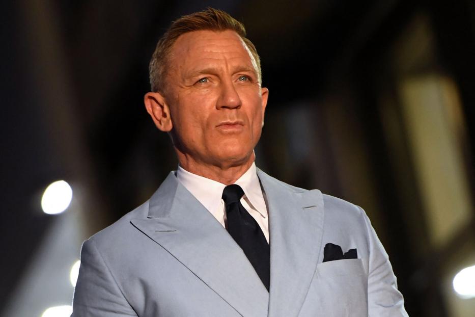 Daniel Craig in einem hellblauen Anzug mit dunkler Krawatte.