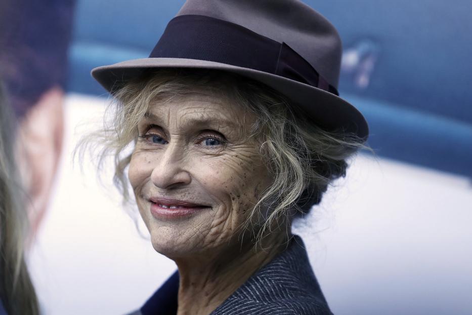 Nahaufnahme von Faye Dunaway mit Hut und grauem Blazer.