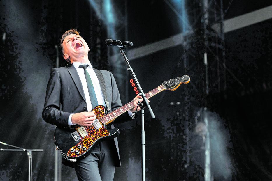 Ein Mann im Anzug spielt Gitarre und singt auf dem 27. Sziget Festival.