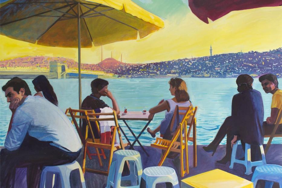 Eine Gruppe von Menschen sitzt in einem Café am Wasser mit Blick auf Istanbul.