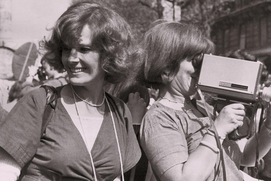 Zwei Frauen, eine lächelnd, die andere mit einem alten Sony-Camcorder.