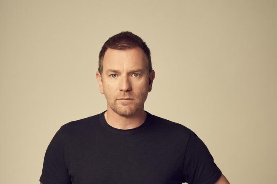 Ewan McGregor posiert mit den Händen in den Hosentaschen.