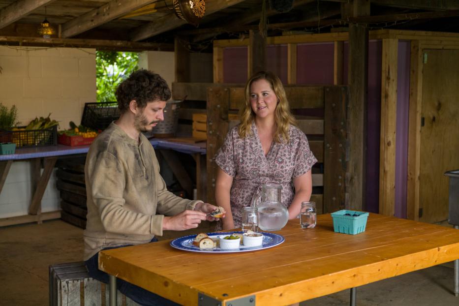 Amy Schumer und ihr Mann Chris Fischer sitzen an einem Tisch mit Snacks.