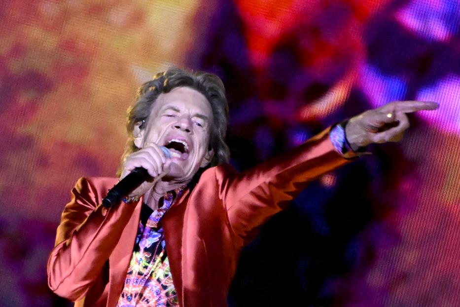 Mick Jagger singt mit erhobenem Zeigefinger auf der Bühne.