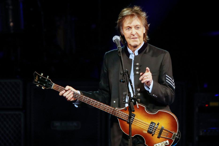 Paul McCartney spielt auf der Bühne Bassgitarre.