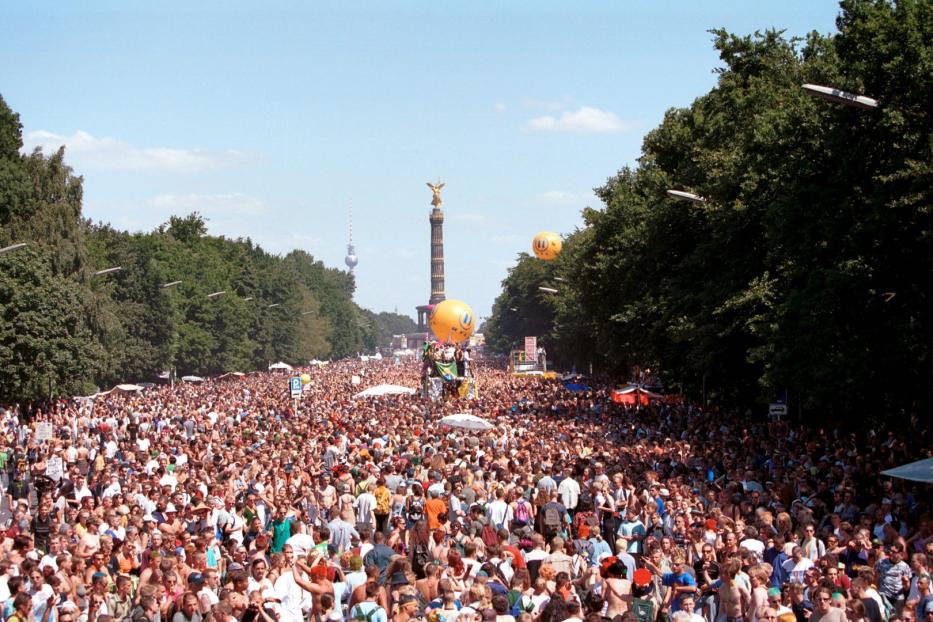 Eine große Menschenmenge feiert auf der Straße mit Blick auf die Siegessäule und den Berliner Fernsehturm.