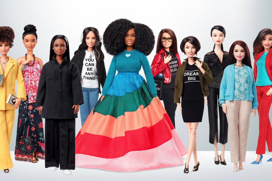Eine Reihe von Barbie-Puppen in verschiedenen Outfits stehen nebeneinander.