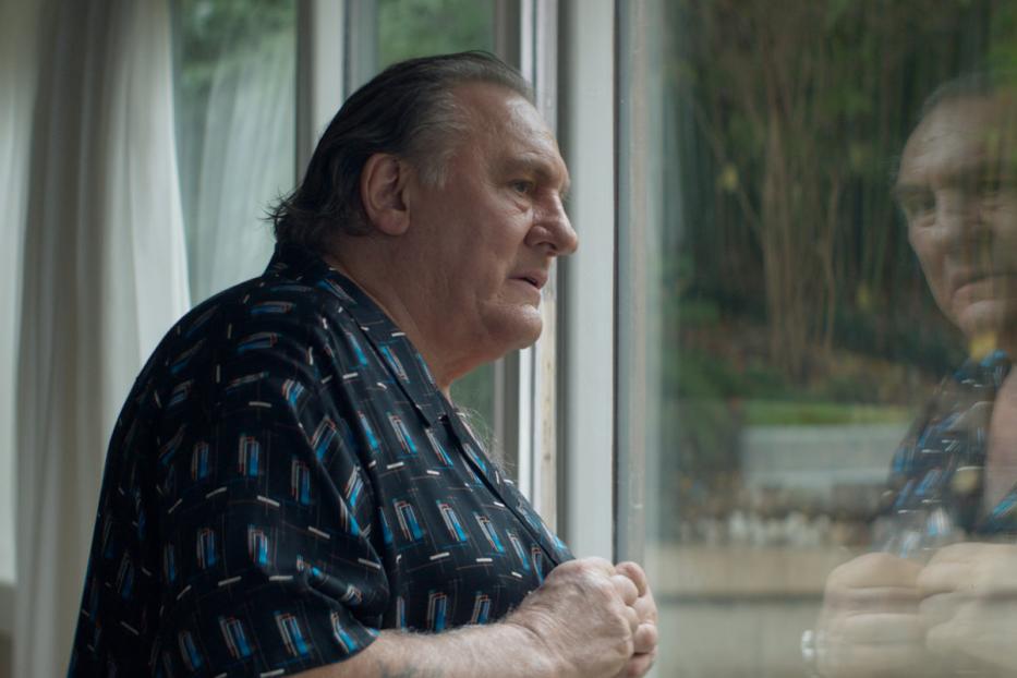 Gérard Depardieu blickt aus dem Fenster.