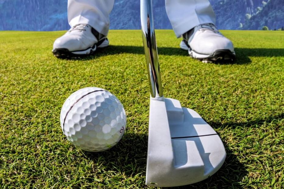 Man playing golf in Kaprun golf center against Kitzsteinhorn, Austria