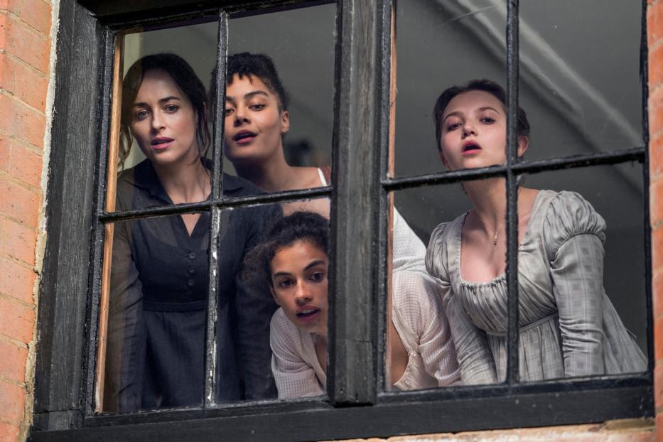 Vier Frauen schauen aus einem Fenster.