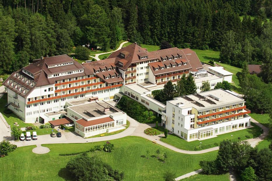 Luftaufnahme eines großen Hotels mit mehreren Gebäuden inmitten einer grünen Landschaft.