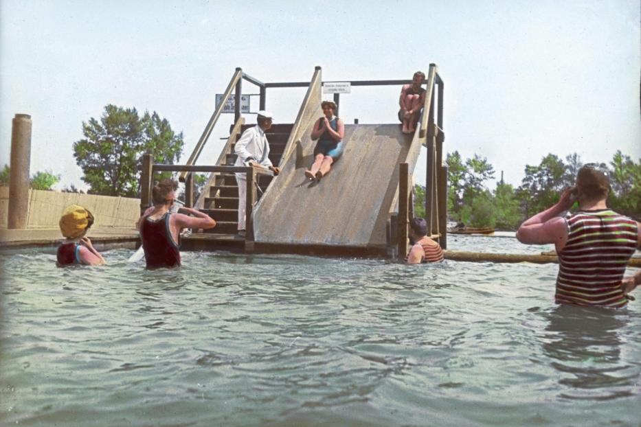 Menschen vergnügen sich auf einer Wasserrutsche in einem Freibad.