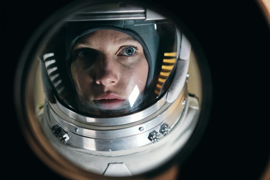 Eine Astronautin blickt durch das Visier ihres Helms.