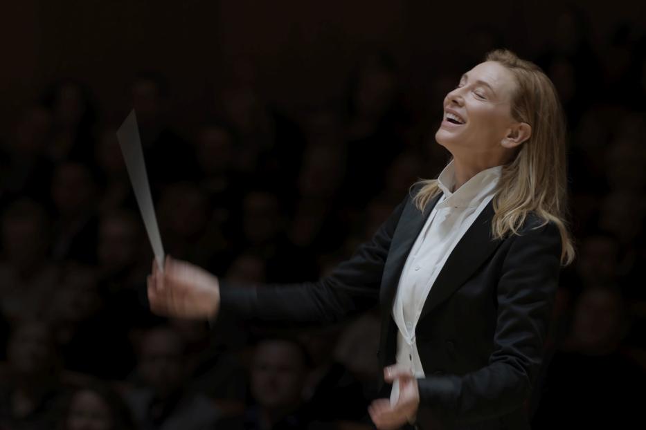 Eine Dirigentin leitet ein Orchester mit einem Taktstock.