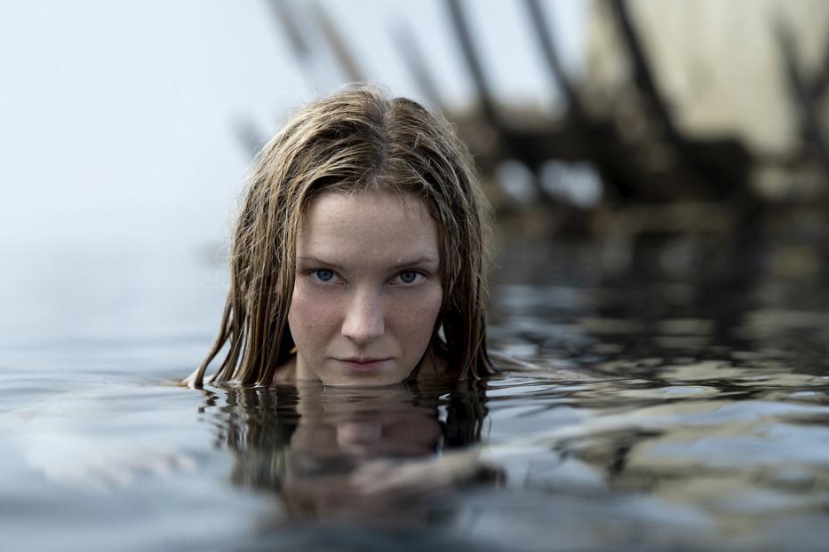 Eine Frau mit blonden Haaren taucht aus dem Wasser auf.
