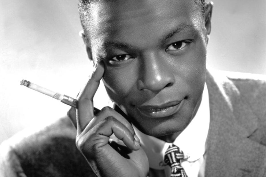 Ein Schwarzweißporträt von Nat King Cole mit einer Zigarette in der Hand.
