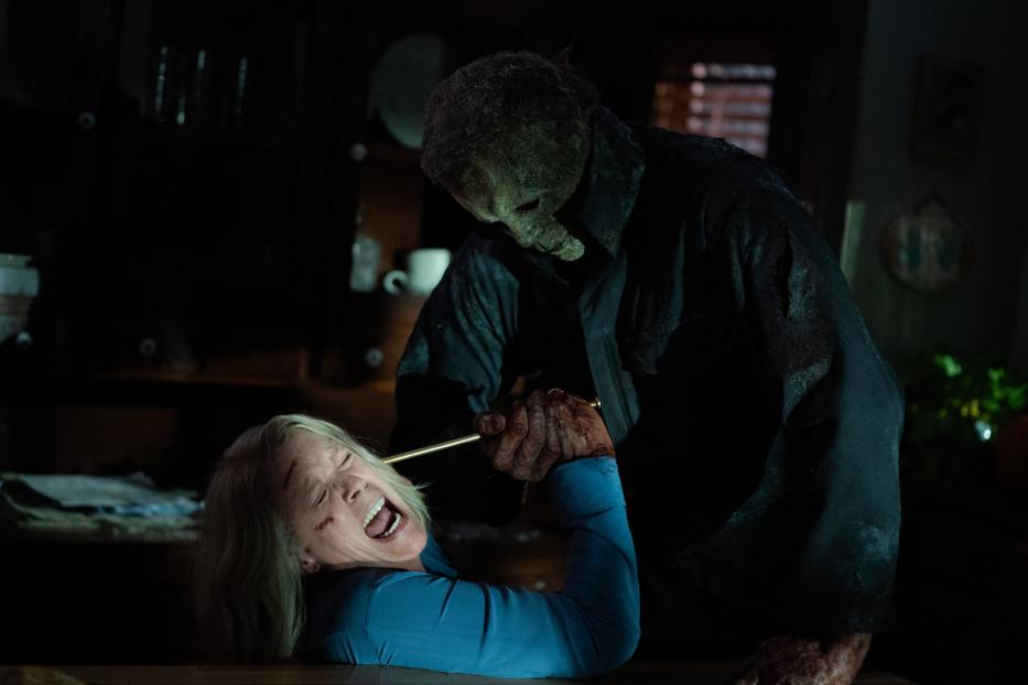 Michael Myers bedroht Laurie Strode mit einem Messer in einem dunklen Raum.