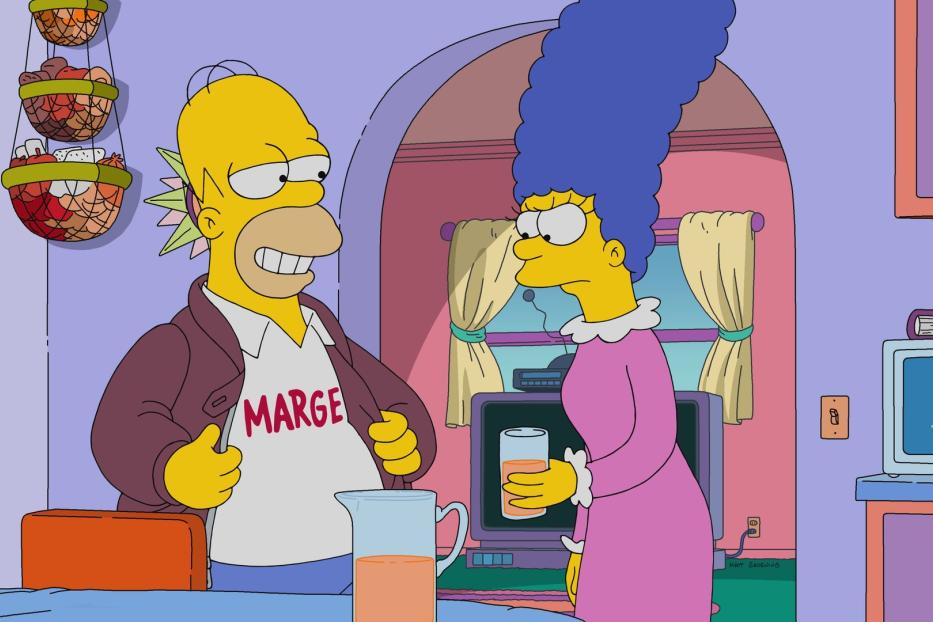 Homer mit „Marge“-T-Shirt und Irokesenschnitt steht mit Marge in der Küche.